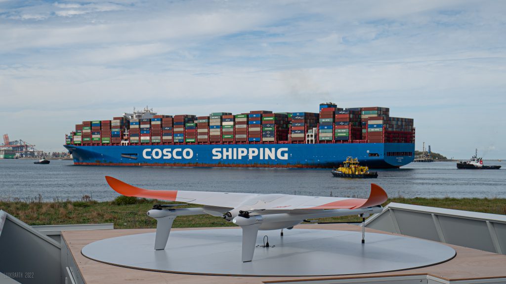Drone with cargo ship on background